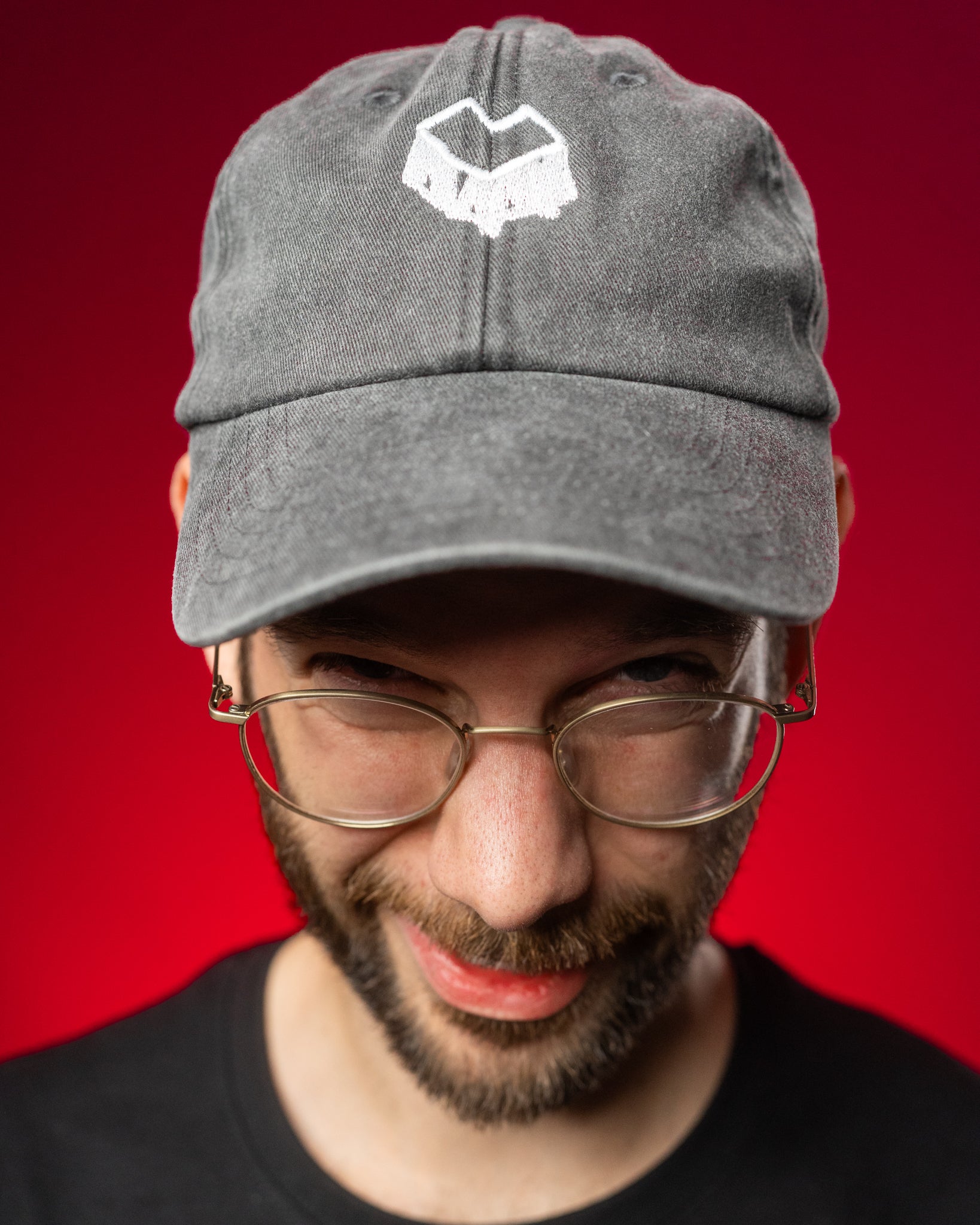 Schwarze Cap aus gewaschener Baumwolle mit leicht gebogener Krempe und sichtbaren Nähten. Auf der Vorderseite befindet sich ein weiß gesticktes Herz-Logo mit kantiger, grafischer Form. Die Cap hat eine klassische Sechspanel-Struktur und wirkt durch den Washed-Look dezent vintage.